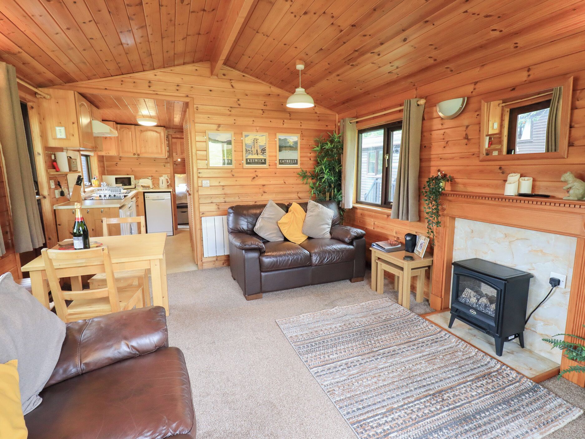 Ein gemütliches Cabin-Interieur mit Wohnbereich, Essbereich, Küche und Kamin.