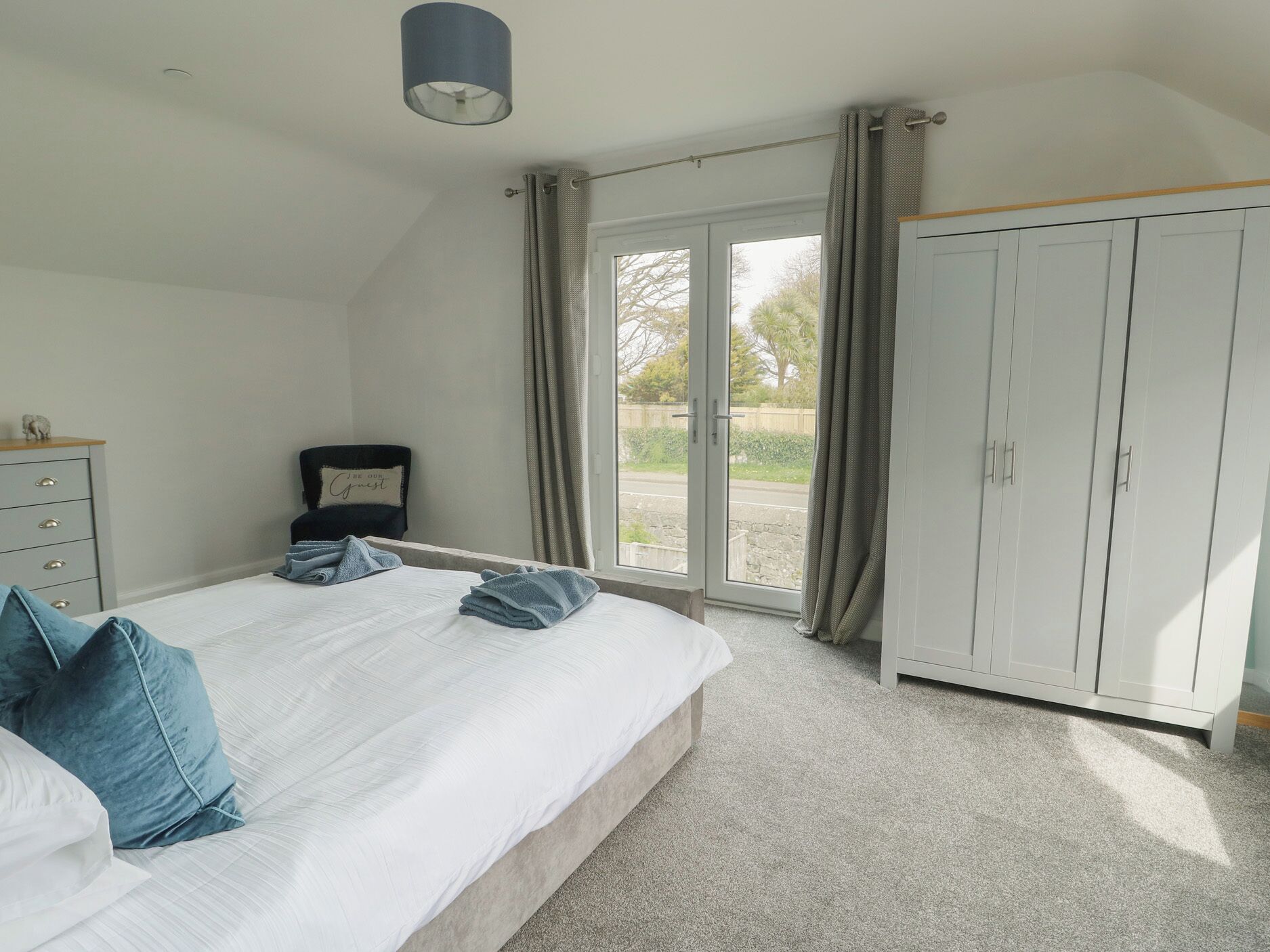 Ein Schlafzimmer mit Bett, Kleiderschrank, Stuhl und Schreibtisch.