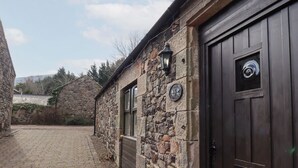 Kivinen rakennus, jossa on tumma puuovi ja kyltti, jossa lukee: ”The 6th Cumbrian”.