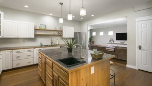 A modern kitchen with wooden cabinets, a granite countertop, a sink, and a refrigerator. - Locust Estates Luxury Home – Downtown Windsor (Windsor)