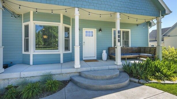 A blue house with a porch, steps, and a bench. - Locust Estates Luxury Home – Downtown Windsor (Windsor)