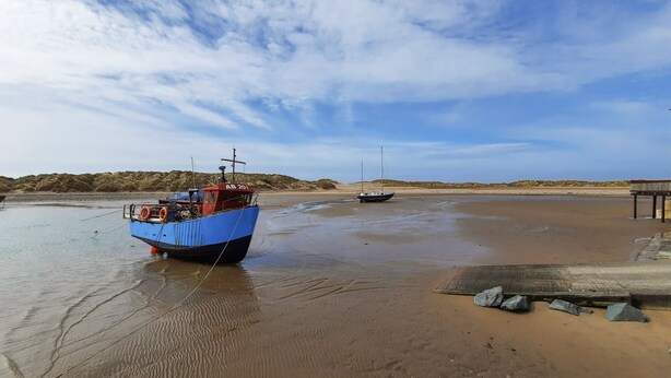 A beach with boats, a wooden pier, and a sandy shore. - Emerald Suite (Barmouth)