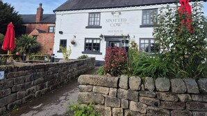Un edificio blanco tradicional con un cartel que dice 'The Spotted Cow Freehouse'.