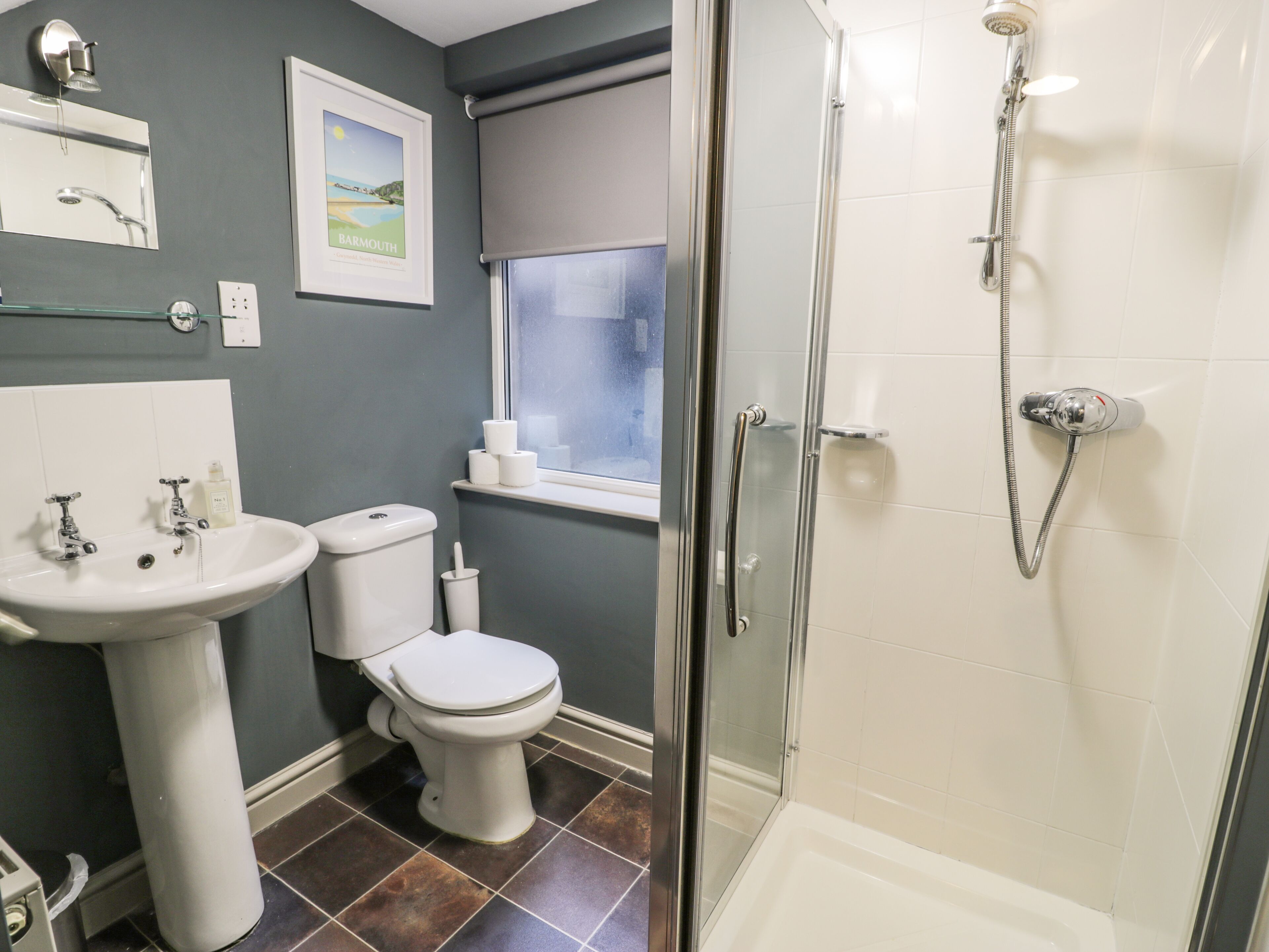 A bathroom with a sink, toilet, and shower.