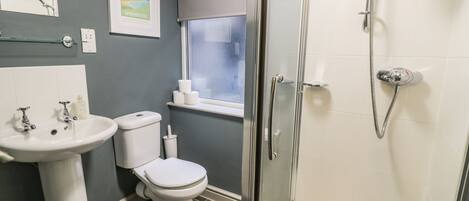 A bathroom with a sink, toilet, and shower.