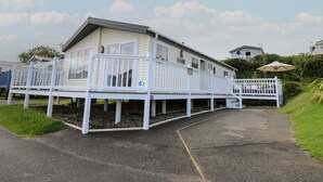 Une maison de plain-pied dotée d’une terrasse, d’un petit porche et d’un chemin menant à l’entrée.