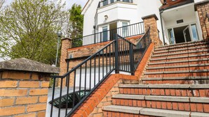 Un bâtiment à deux étages doté d’un escalier en briques et d’un balcon.