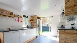 Een moderne keuken met witte kasten, houten details en een groot eiland.
