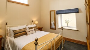 A bedroom with a bed, bedside tables, a window with a view, and a mirror. - West Reins (Barnard Castle)