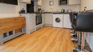 A modern kitchen with a built-in oven, microwave, and washing machine.