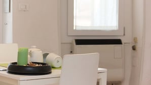 Eine Küche mit einer weißen Arbeitsplatte, einem grünen Kerzenlicht, einem weißen Wasserkocher und einer schwarzen Schüssel.