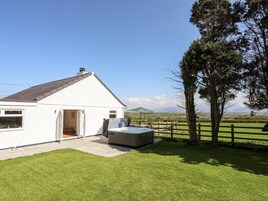 Una casa blanca con un patio, un jacuzzi y vistas al campo.