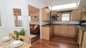 A compact kitchen with wooden cabinets, a built-in oven, and a microwave.