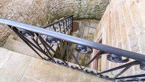 Eine Steintreppe mit Metallgeländern und Handlauf.