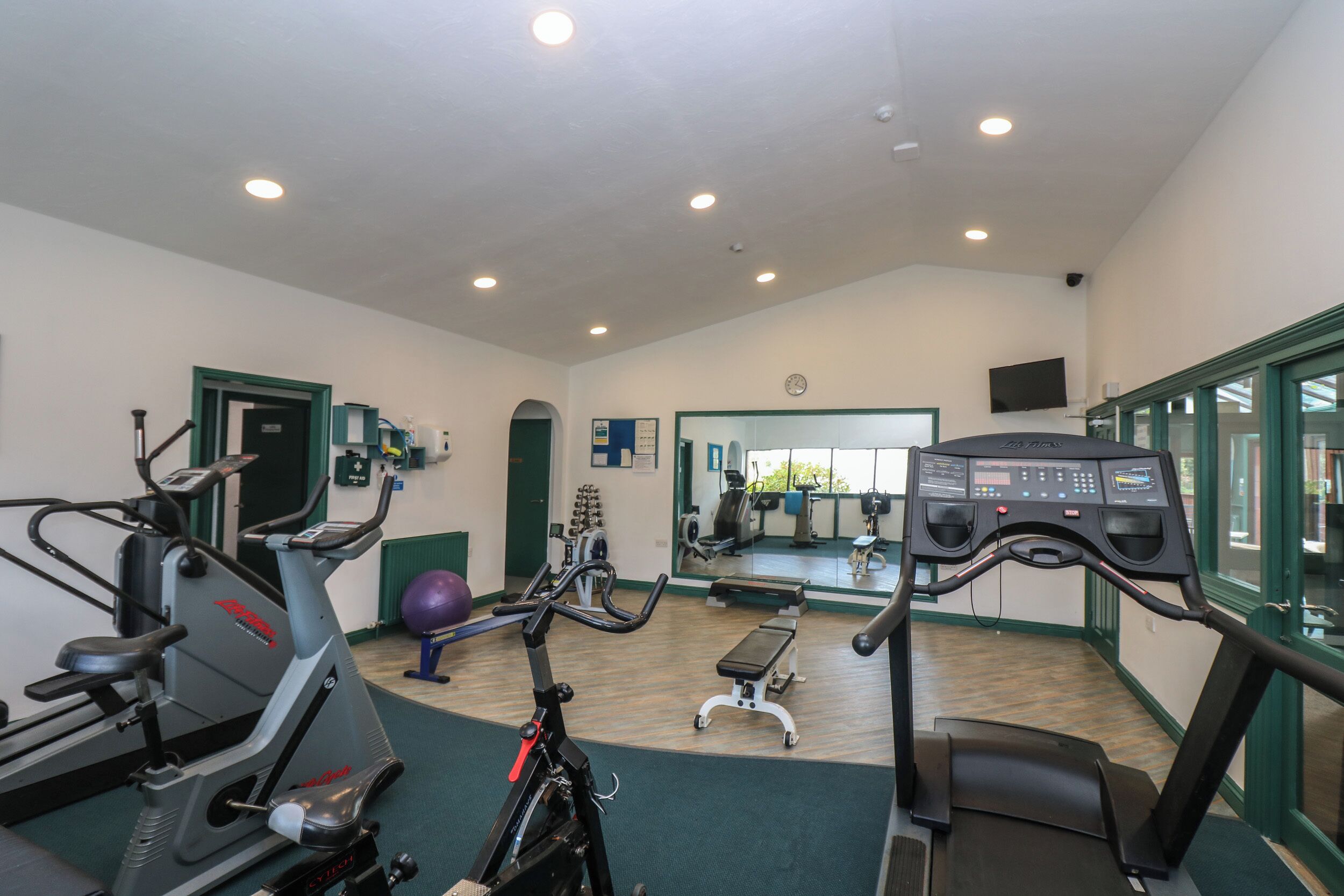 A gym with treadmills, stationary bikes, and exercise equipment.