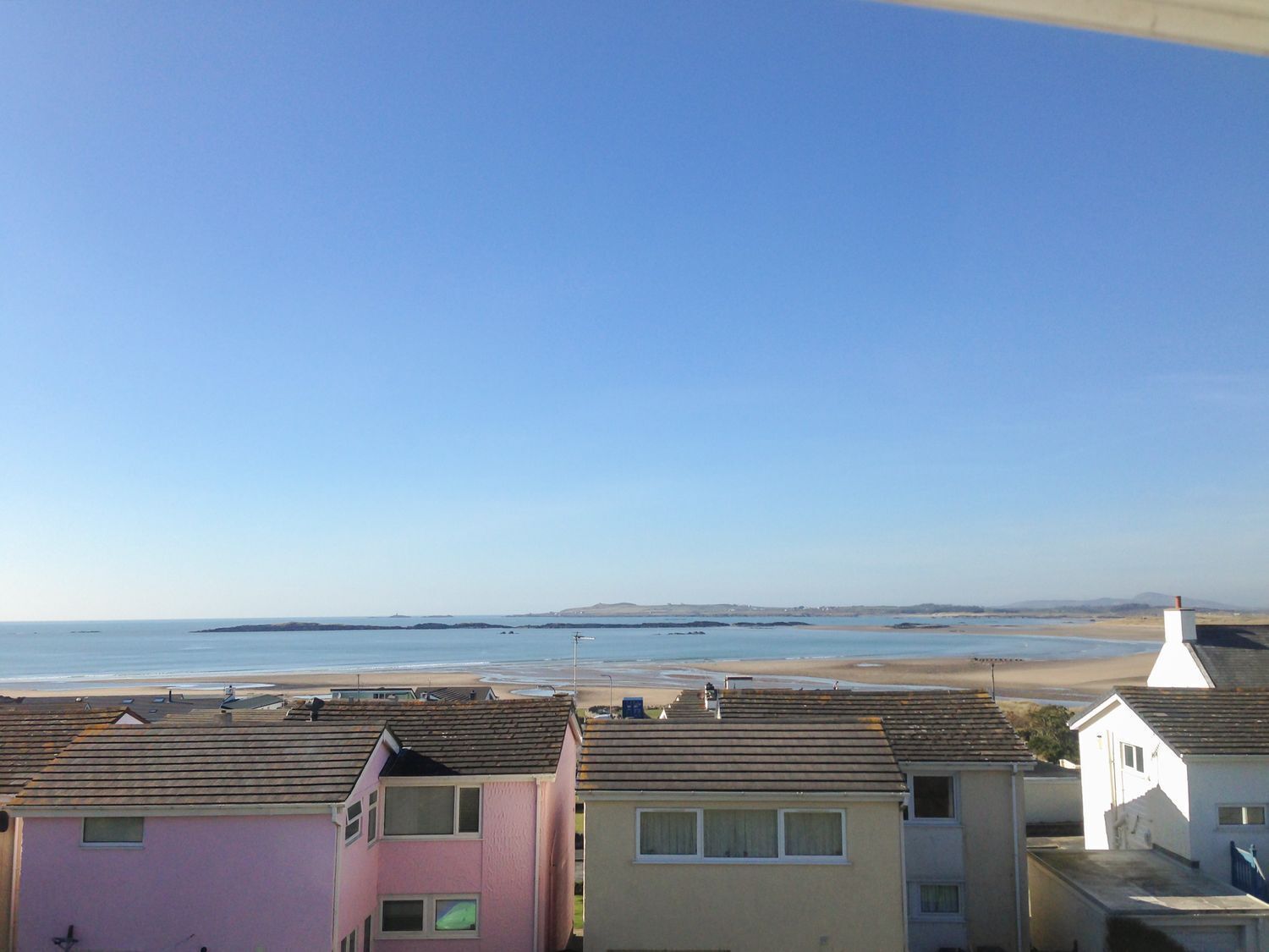 A coastal residential area with houses overlooking the beach.