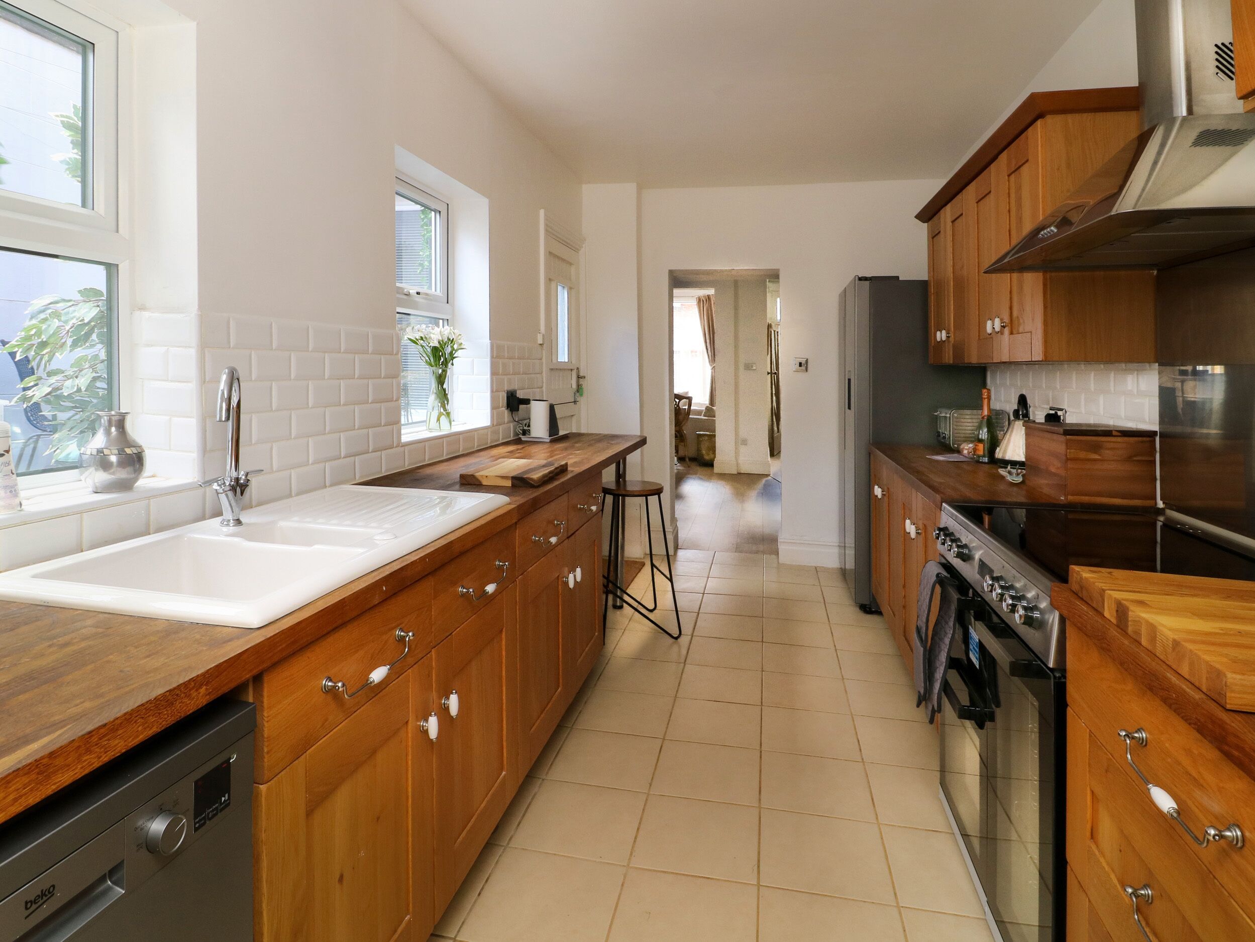 A modern kitchen with wooden cabinets, a stainless steel sink, and a built-in oven.
