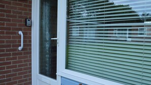 A house number '20', a white door, and a window with blinds. - 20 Siesta Mar (Norwich)