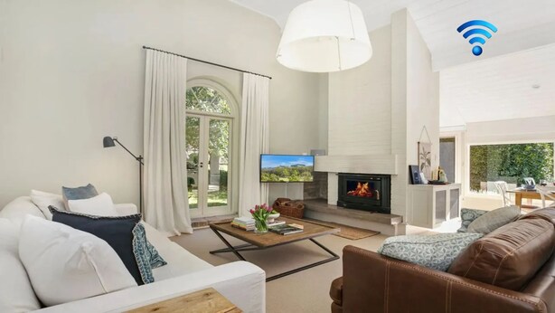 A modern living room with a fireplace, a sofa, a coffee table, and a TV. - Protestant Hall - complete peace and tranquility (Wildes Meadow)
