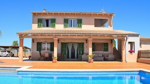 A two-story house with a swimming pool in front. - Ballester 034 fantastic finca with private pool, large terrace, barbecue and air conditioning (Santa Margalida)
