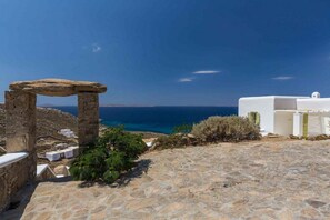 Experience the tranquility of a centuries-old coastal ruin, set amidst a serene stone-paved area with breathtaking sea views.