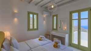 Une chambre d’hôtel avec un lit, un bureau et une vue sur la mer.
