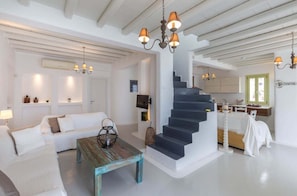Stylish living space with a staircase, seating area, and kitchen.