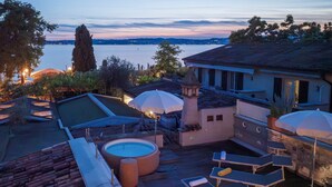 A rooftop terrace with a swimming pool, sun loungers, and umbrellas. - Arcimboldo House 2+2, Emma Villas (Sirmione)
