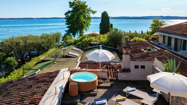 A rooftop terrace with a swimming pool, lounge chairs, and umbrellas, overlooking a lake. - Arcimboldo House 2+2, Emma Villas (Sirmione)
