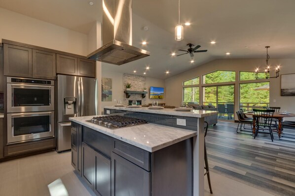 Una cocina moderna con electrodomésticos integrados, una isla grande y un comedor con vistas.