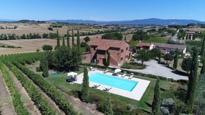Una vila amb piscina, envoltada de vinyes i un paisatge rural.