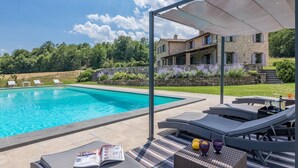 A swimming pool with lounge chairs and a covered seating area. - Villa Le Fontane 12, Emma Villas (Todi)