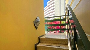 Una escalera con barandilla metálica y un objeto fijado a la pared.