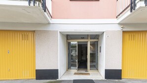 A building entrance with a glass door, a number '48' sign, and yellow doors on either side.