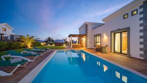 A modern pool area with lounge chairs and a clear blue pool. - *Luxury Villa* | Heated Pool, Sea & Mountain Views - High Speed WIFI. (Playa Blanca)