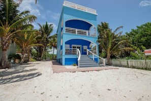 Un immeuble de deux étages avec une façade bleue et un escalier central.