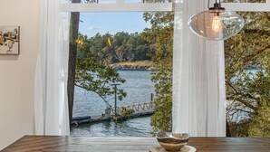 Un espace repas avec vue sur un lac et un pont.