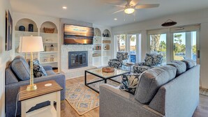 A spacious living room with a fireplace, comfortable seating, and a television.