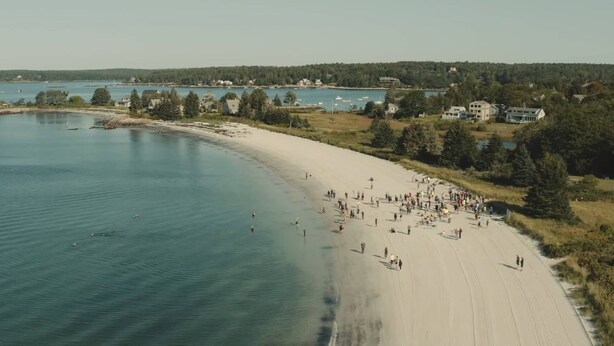 A beach with people walking along the shore, surrounded by trees and houses in the background. - Next Avail. Aug 22 - 3 night min - AC - Premier Cottage, King Bedroom, Pets Free (Round Pond)