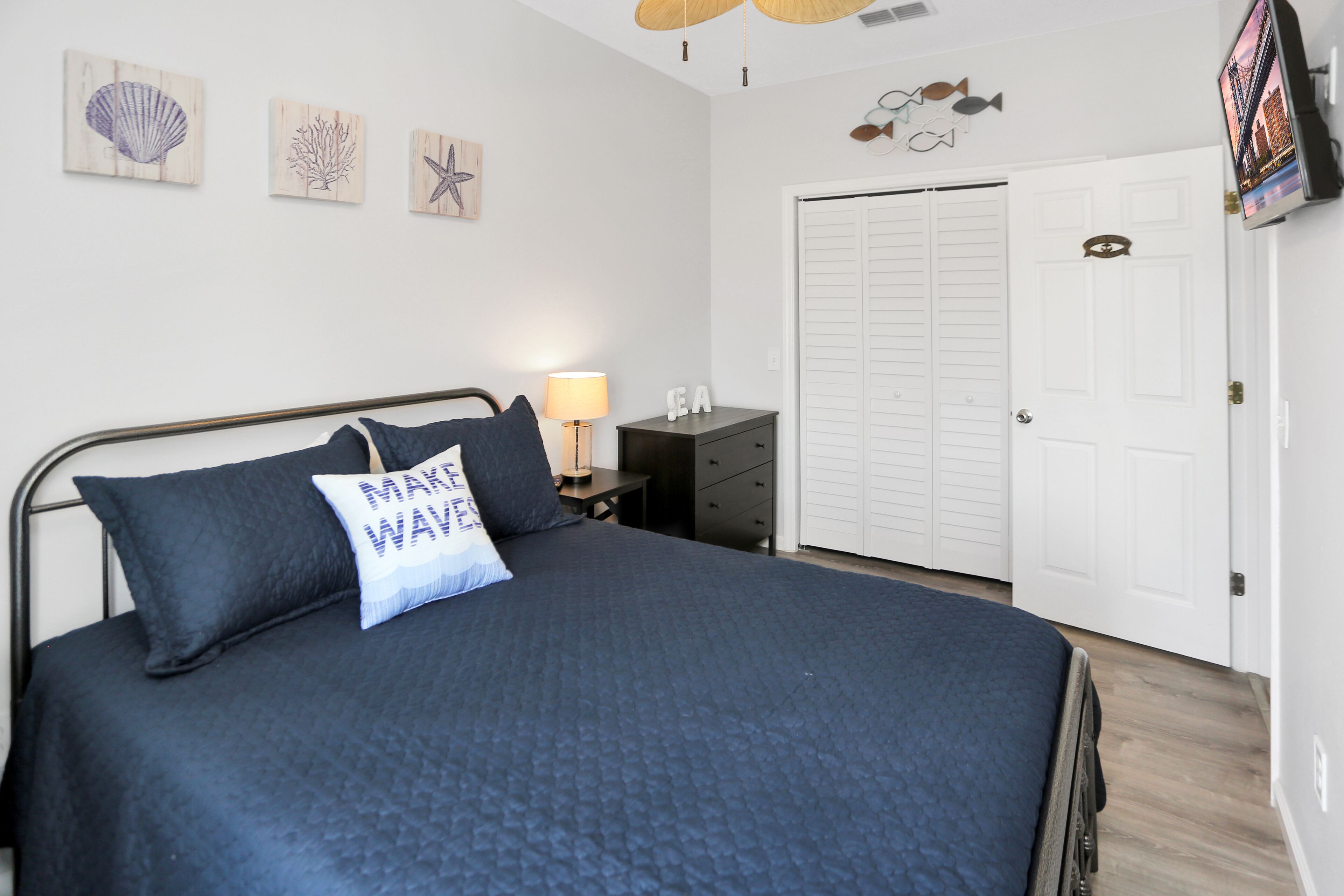 A bedroom with a bed, a nightstand, a lamp, and a wardrobe.