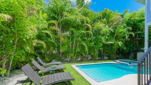 A swimming pool surrounded by lush greenery and outdoor seating.