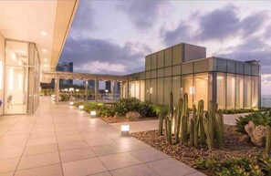 Experience the sleek, contemporary design of this hotel's inviting facade, featuring a wide entrance and beautifully landscaped surroundings.