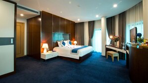 Een moderne hotelkamer met een groot bed, een bureau en een stoel.