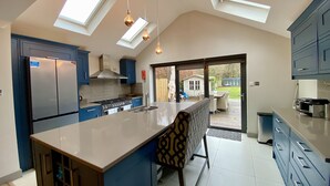 A modern kitchen with skylights, a large island, and a view to the backyard.