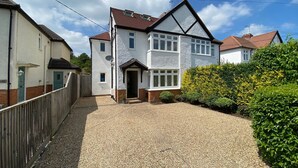 A two-story house with a gravel driveway and a wooden fence.