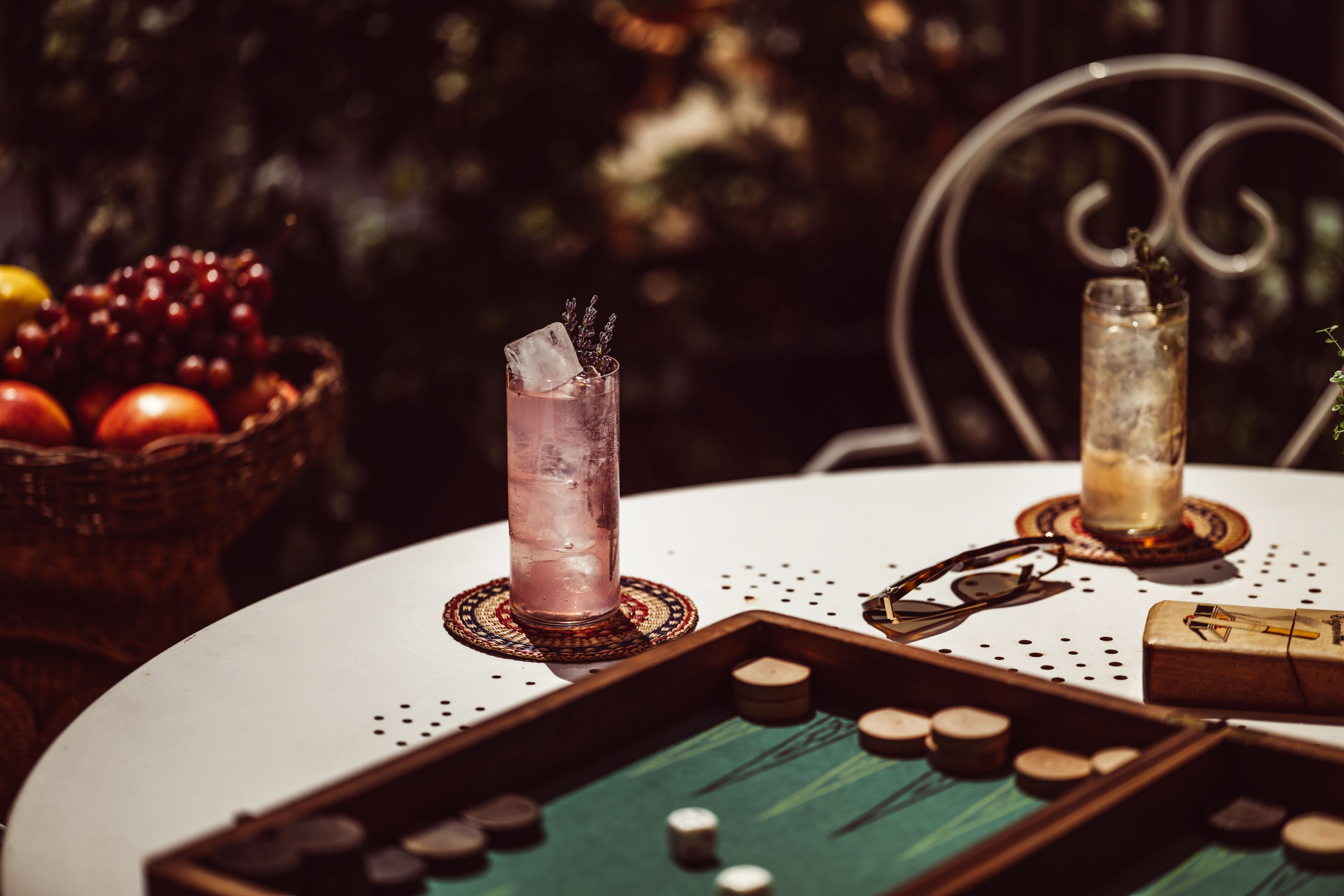 Ein Tisch mit einem Getränk, einer Obstschale und einem Kartenspiel.