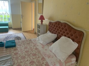 Relax in this serene bedroom with a large bed and comfortable seating area.