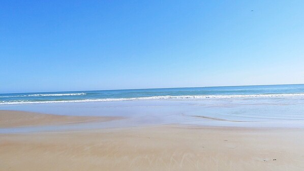 A beach with a clear sky and calm sea. - PRIVATE HOME Private pool, steps to the BEACH (Port Orange)