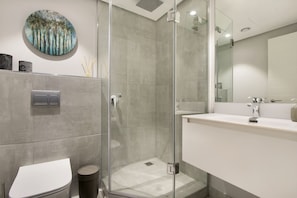 A modern bathroom with a glass-enclosed shower, a white sink, and a toilet. - 16 On Bree - Unit 2810 (Cape Town)