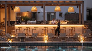 A poolside bar area with wicker chairs and a bar counter.